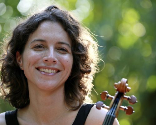 Woman in curly hair smiling.